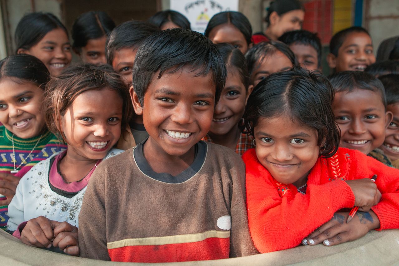 A joyful group of schoolchildren in a rural village in Bangladesh, radiating happiness.